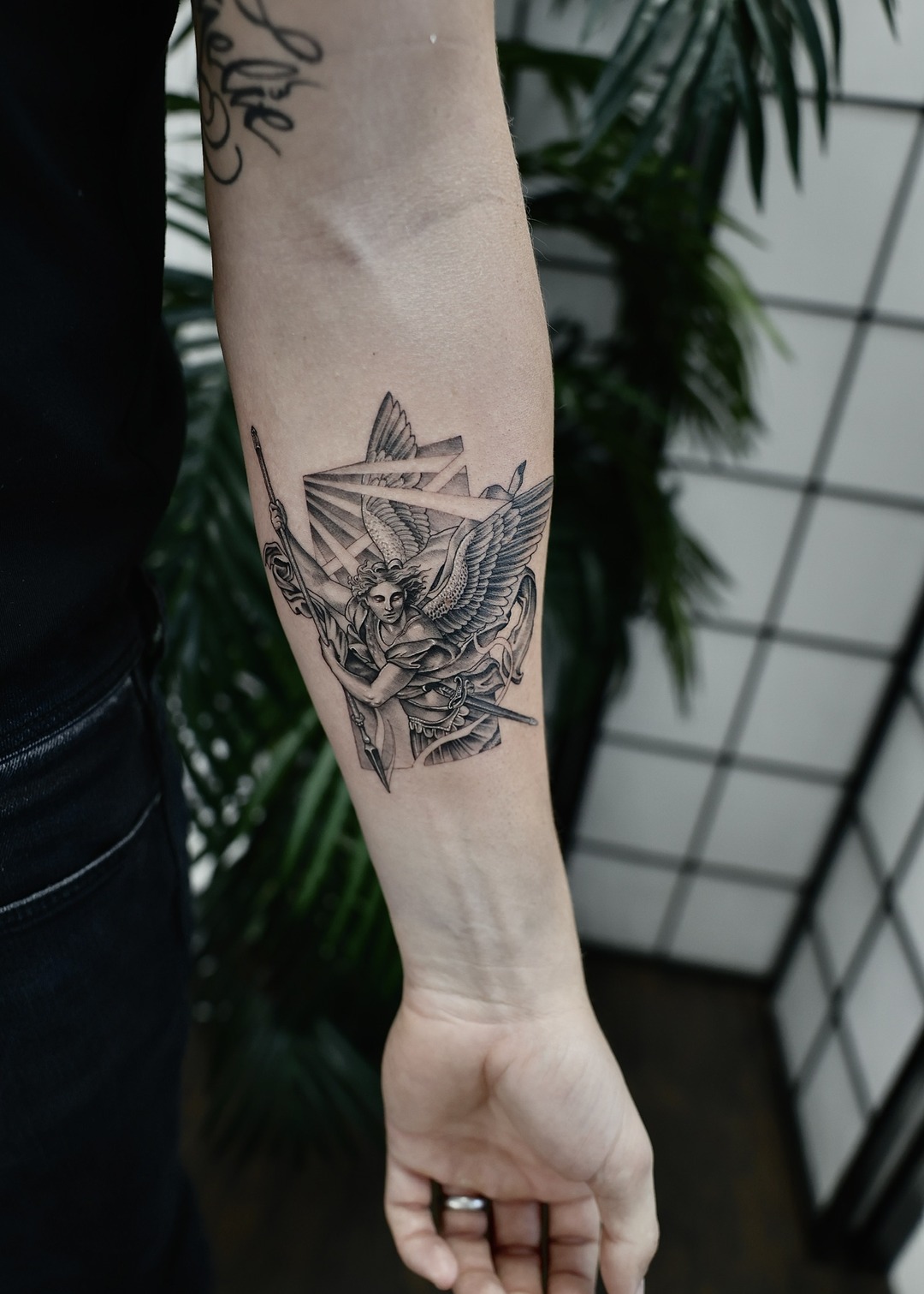 Archangel Michael with wings and spear geometric forearm tattoo, black and grey by Matt Roe, Kensington London