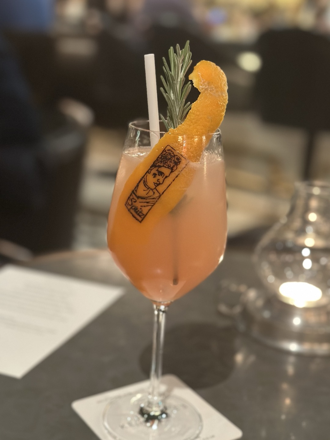 Cocktail with an edible Matt Roe tattoo garnish at Corinthia London