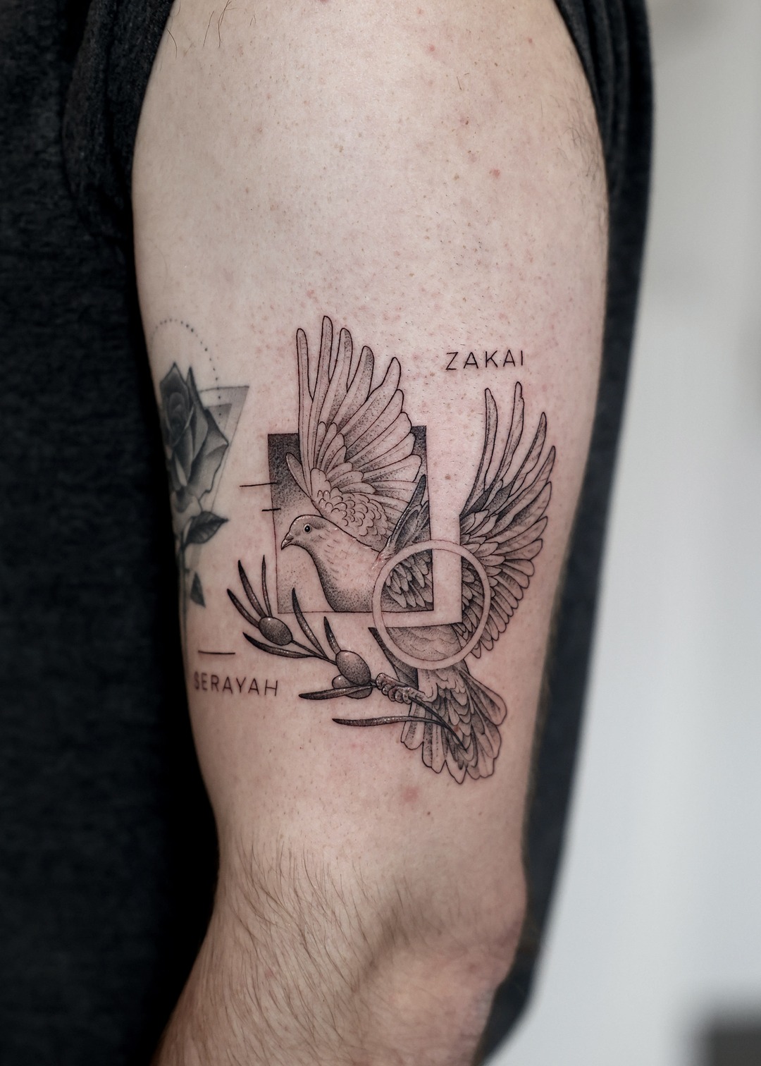 Dove olive branch cross names upper arm tattoo, black and grey by Matt Roe, Kensington London
