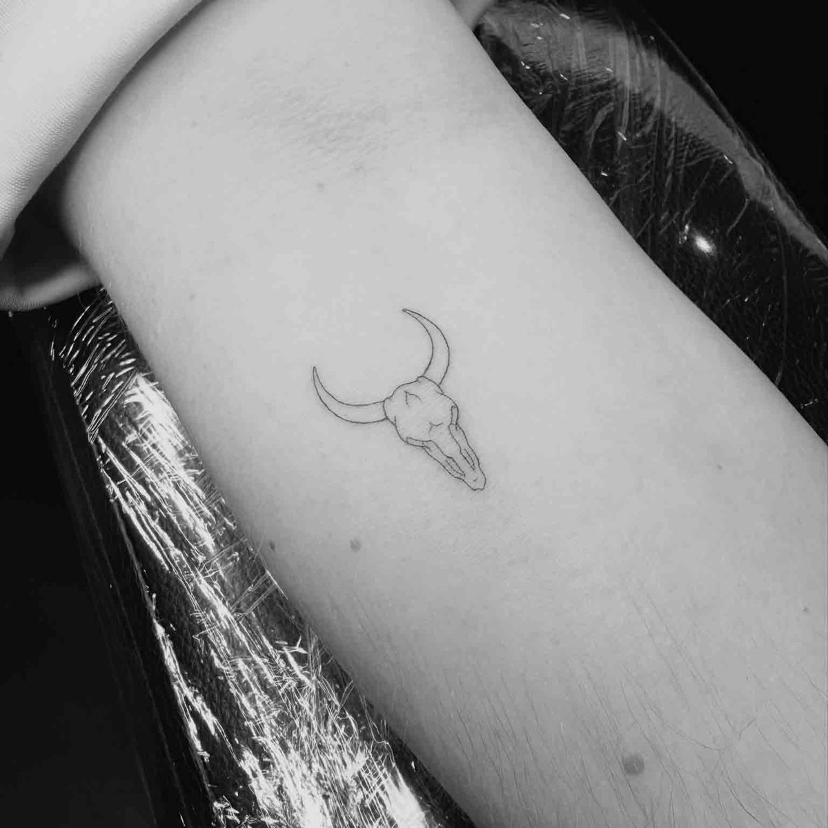 Fine line bull skull tattoo on forearm by Matt Roe, London