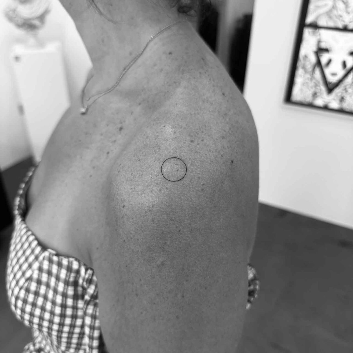 Minimal fine line circle tattoo on shoulder by Matt Roe, London