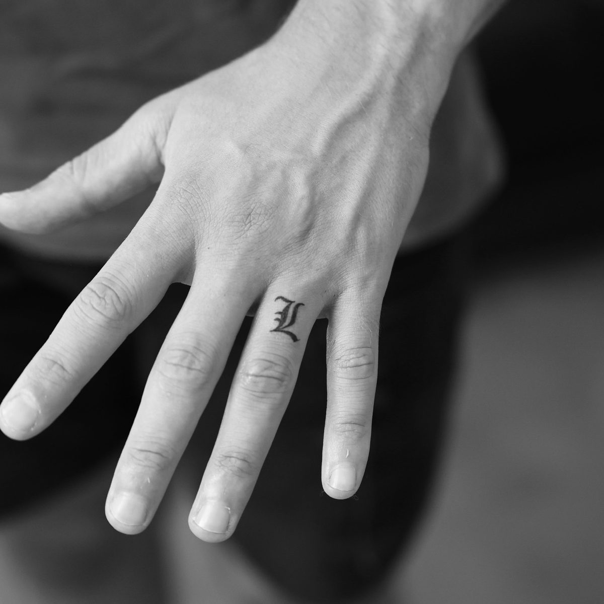 Old English letter L tattoo on ring finger by Matt Roe, Kensington London
