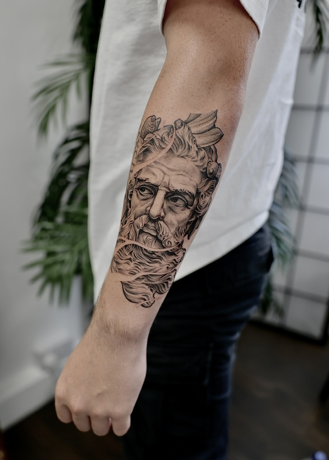 Poseidon bust sculpture forearm tattoo, black and grey by Matt Roe, Kensington London