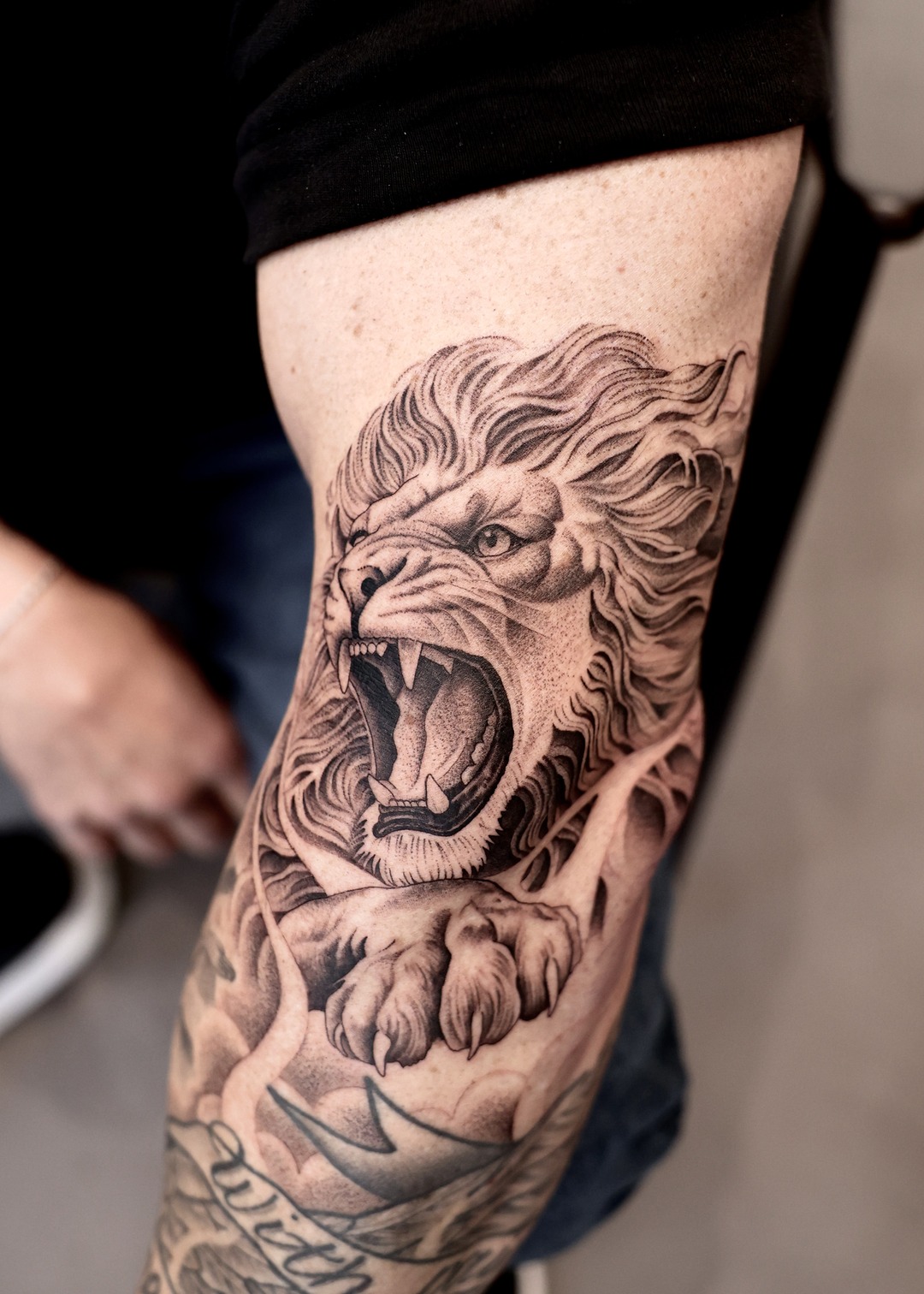 Roaring lion knee tattoo black and grey by Matt Roe, Kensington London