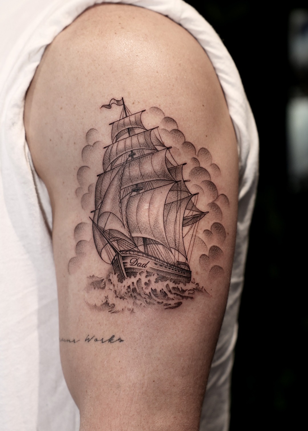 Sailing ship with clouds upper arm tattoo, black and grey by Matt Roe, Kensington London
