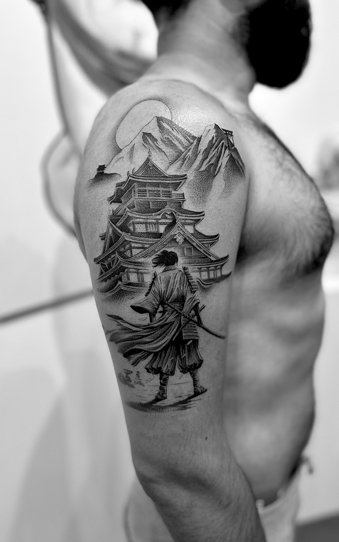Samurai before a mountain castle under a moon, upper arm tattoo, black and grey by Matt Roe, Kensington London