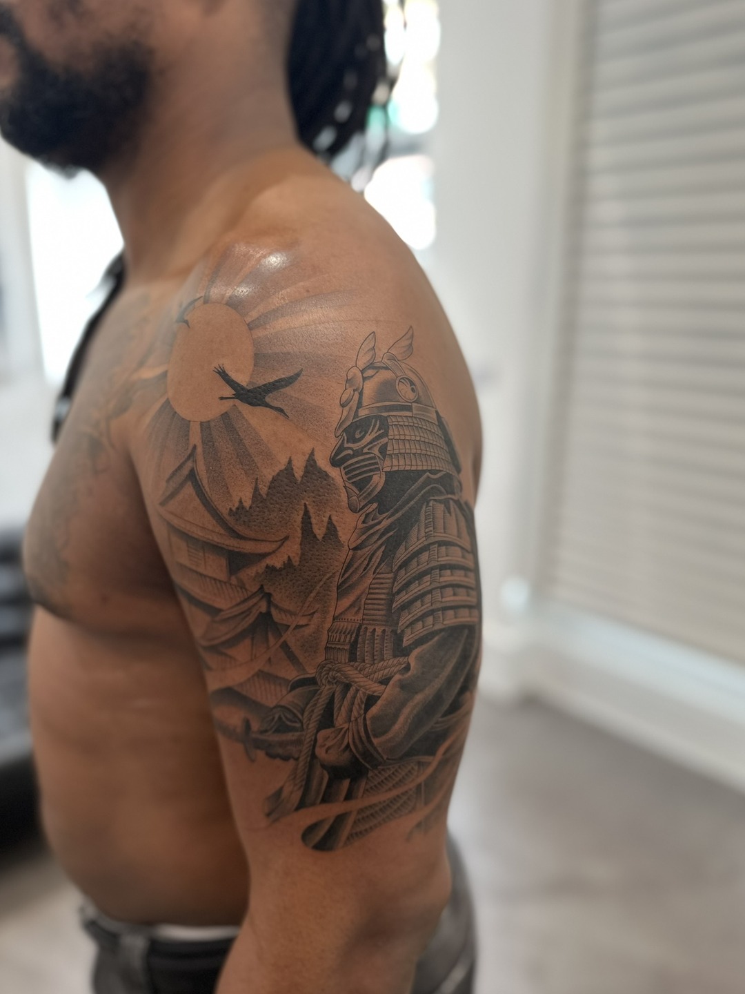 Armoured samurai warrior with sun and crane, upper arm tattoo, black and grey by Matt Roe, Kensington London