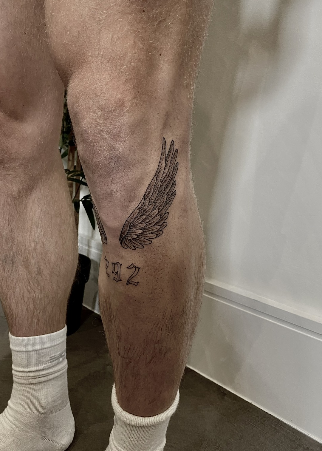 Single wing with numerals, calf tattoo, black and grey by Matt Roe, Kensington London