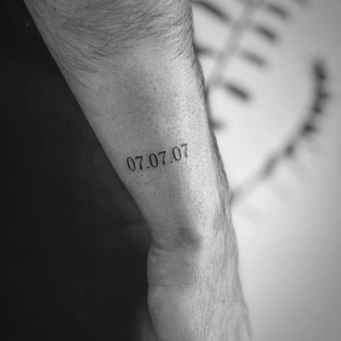 Small fine line date tattoo on wrist by Matt Roe, Kensington London