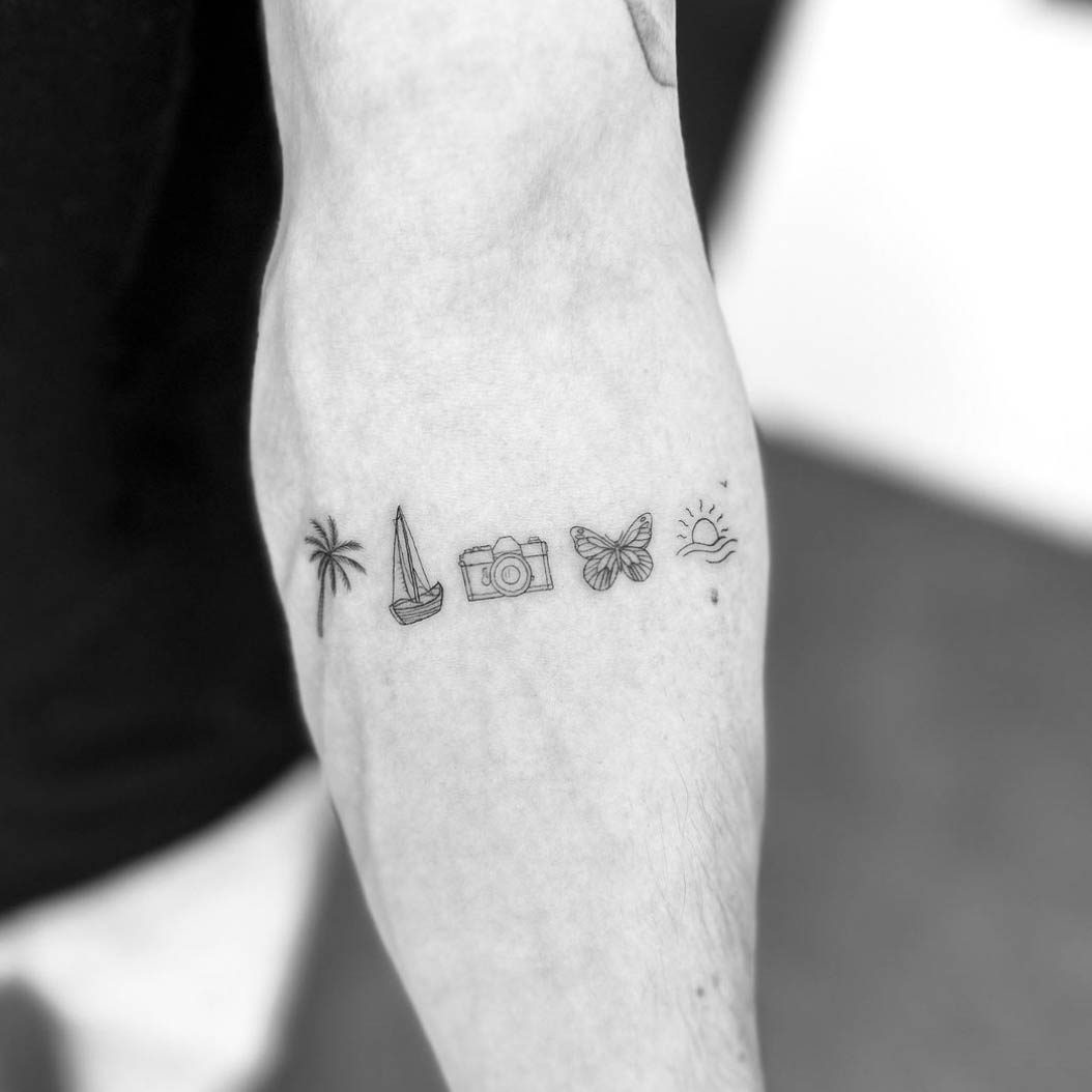 Row of tiny fine line icons tattoo on forearm including palm tree, sailboat, camera, butterfly and sun by Matt Roe, Kensington London